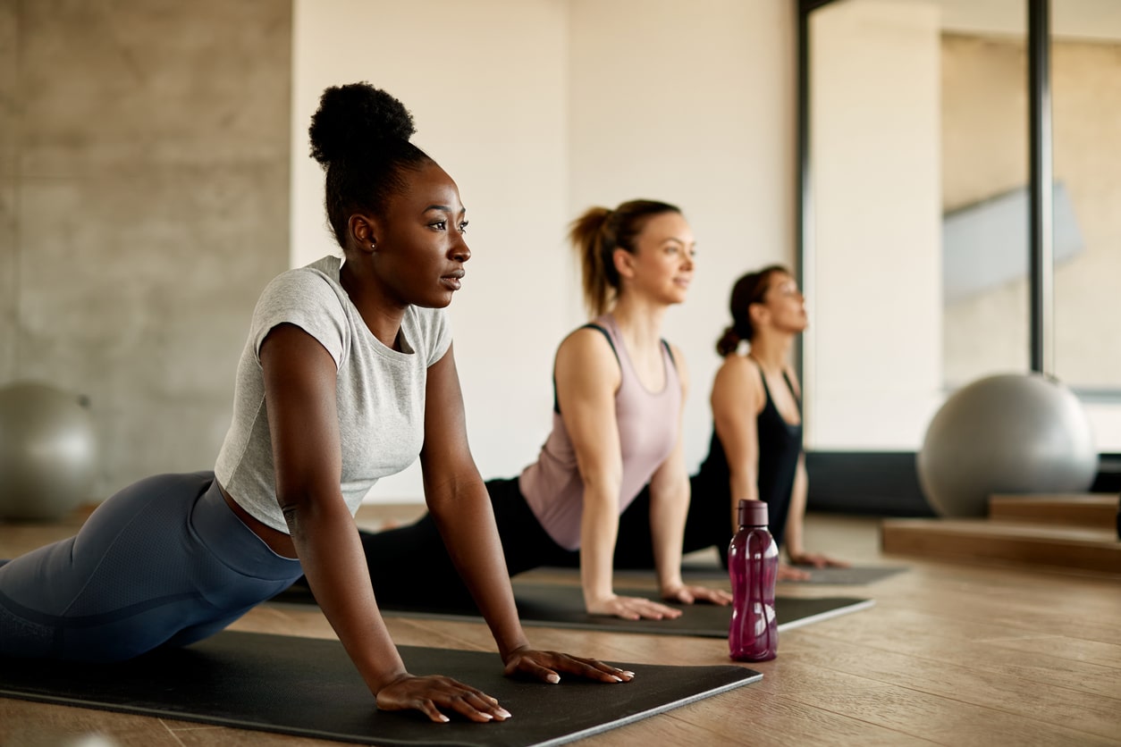 A group of women doing yoga to prevent back pain 