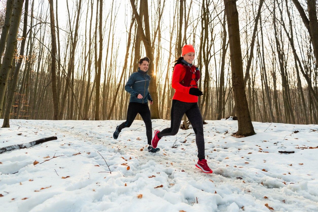 Two people runnign in the snow 