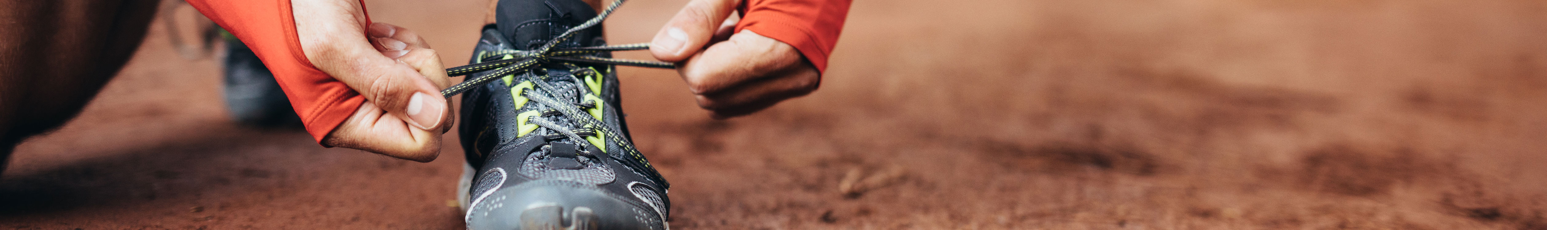 A person tying up their neutral running shoes