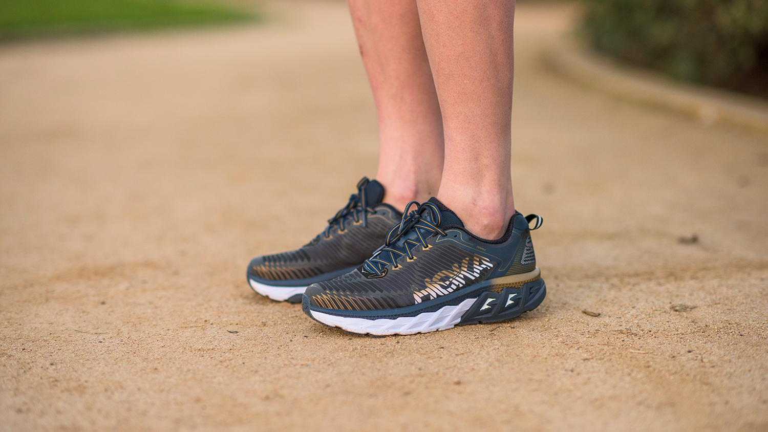 A person wearing Hoka running shoes on a trail 