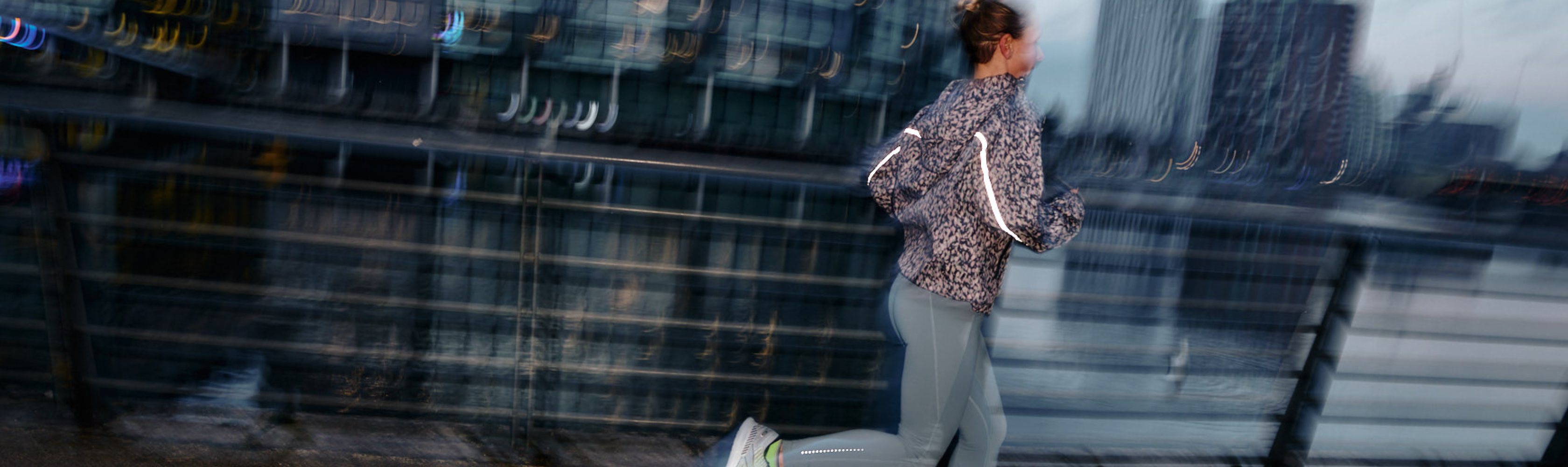 A lady running in across a bridge in the dark