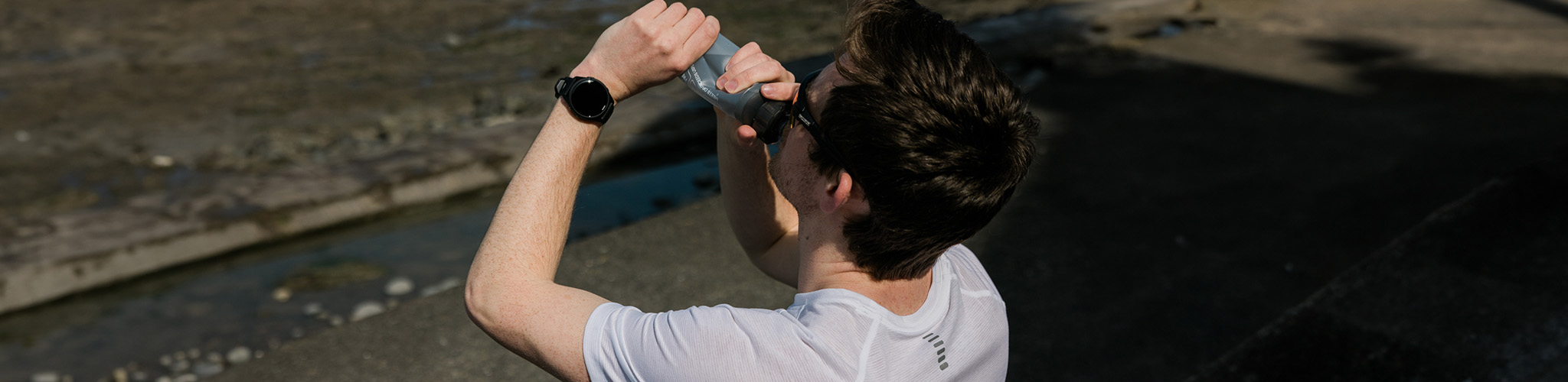 Shop nutrition and hydration. A man drinking from a water bottle. 