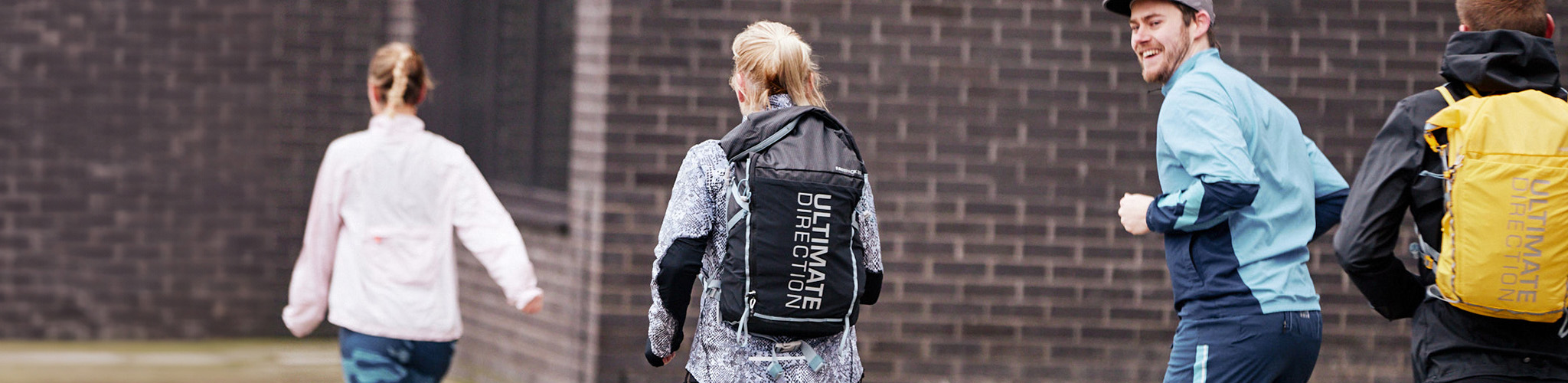 Shop running packs. A woman running wearing an Ultimate Direction running pack. 