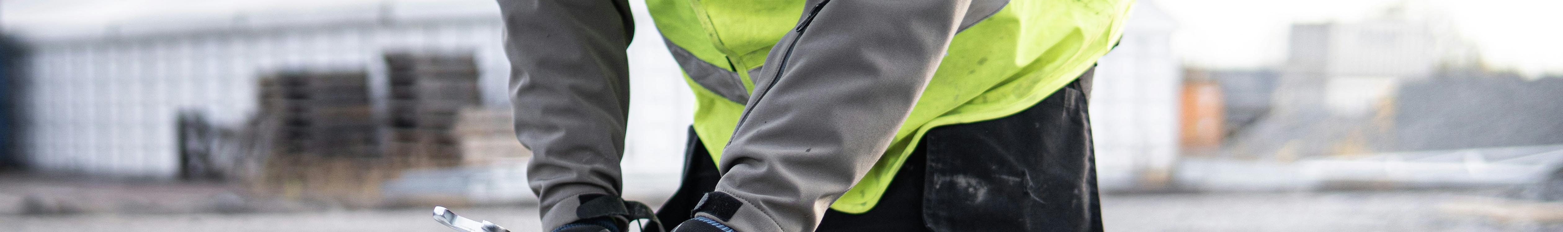 Hi Vis Waterproof jackets. A woman cycling on a bike wearing a hi vis waterproof jacket. 