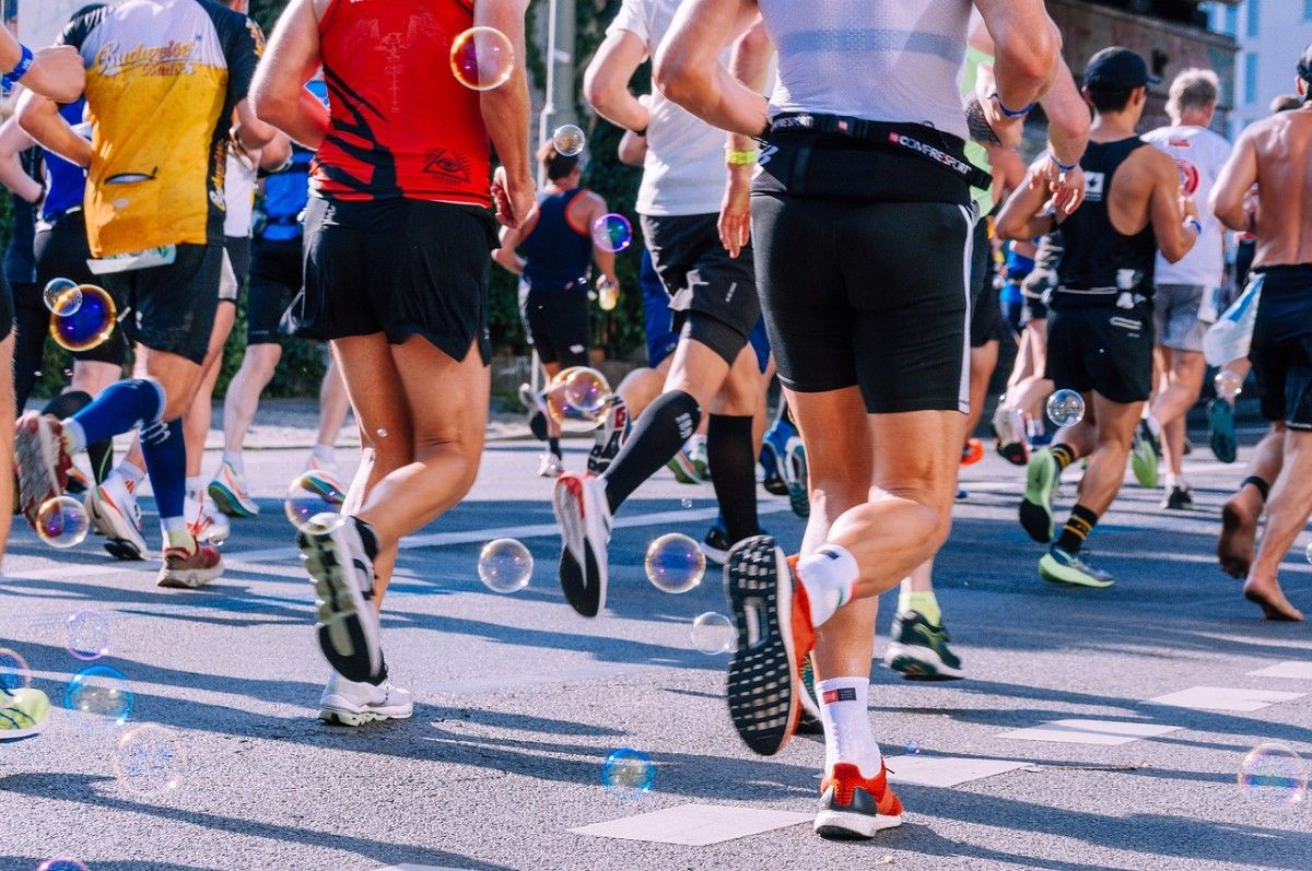 A group of people running the Boston Marathon with bubbles floating around them 