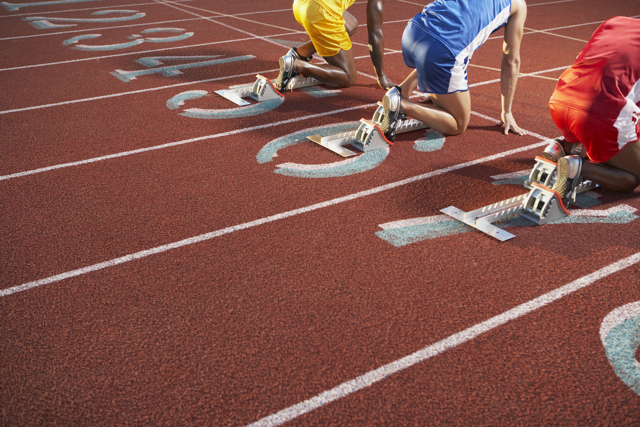 Three people crouched down ready to race 