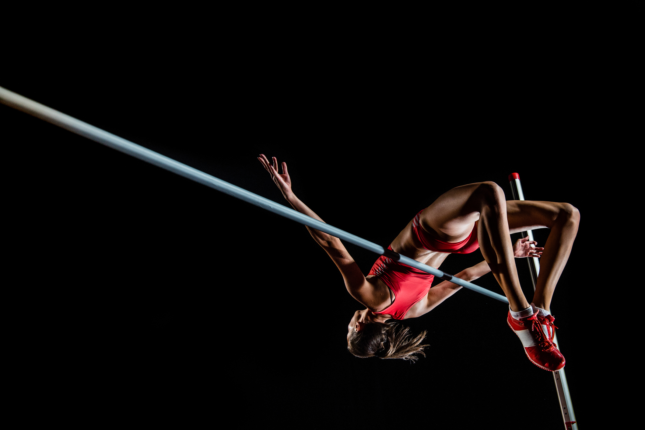 A woman jumping over the high jump 