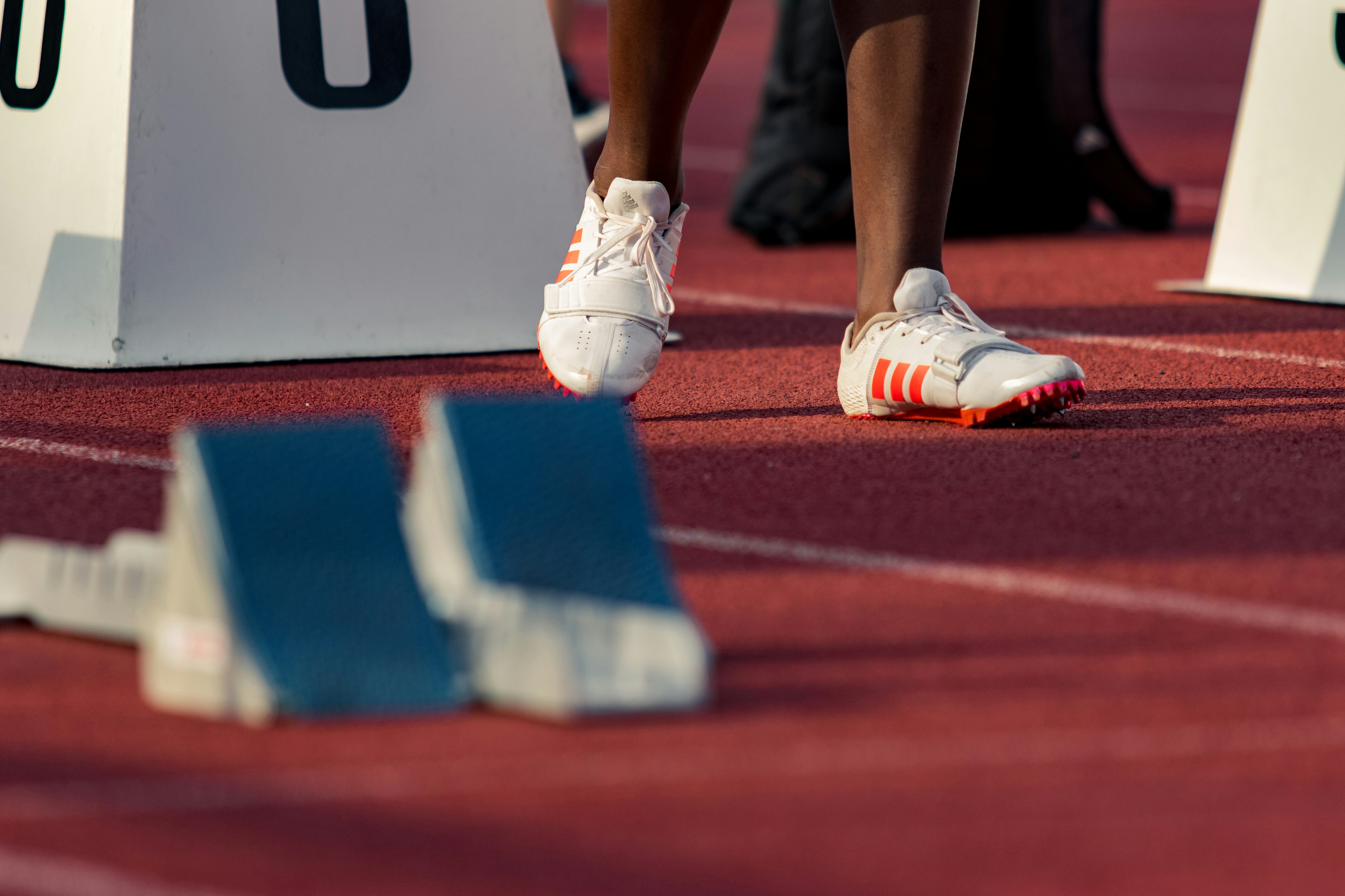 Adidas Running Shoes. A person wearing their Adidas running spikes on a running track 