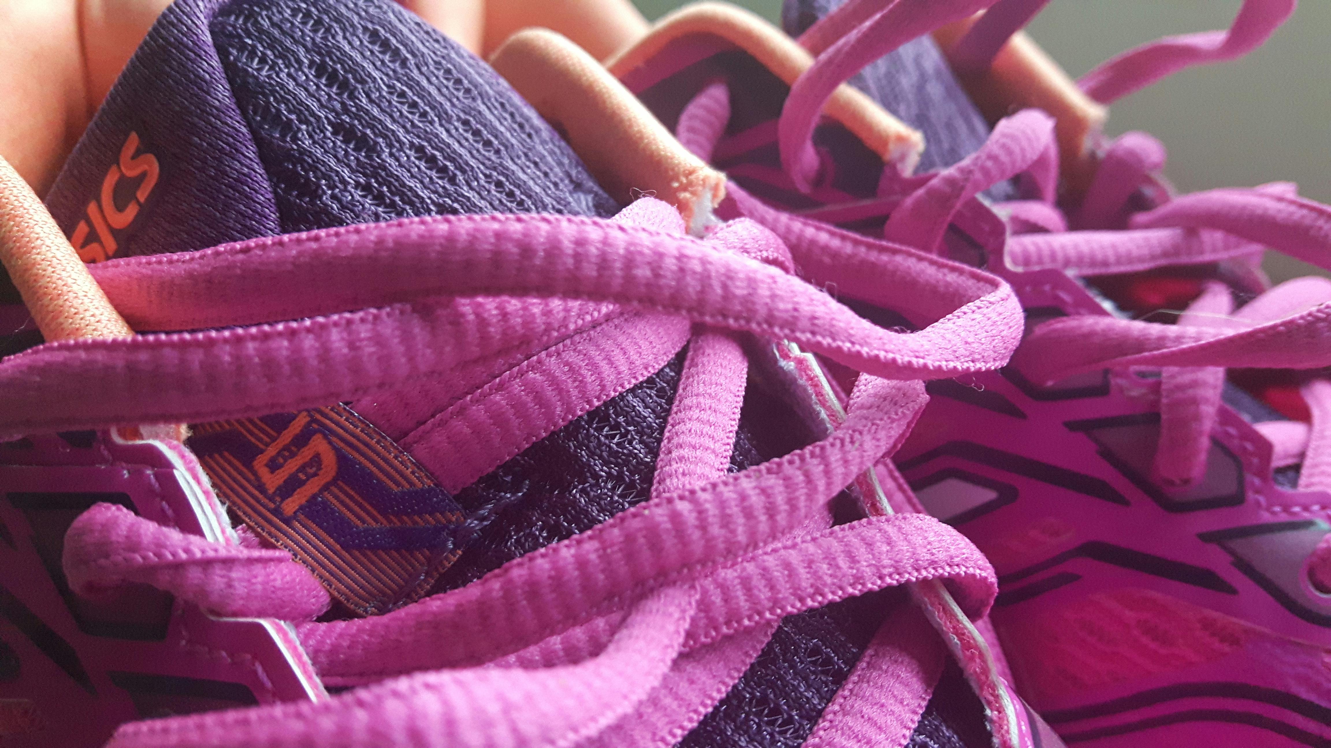 A close up of a pair of pink Asics shoes 