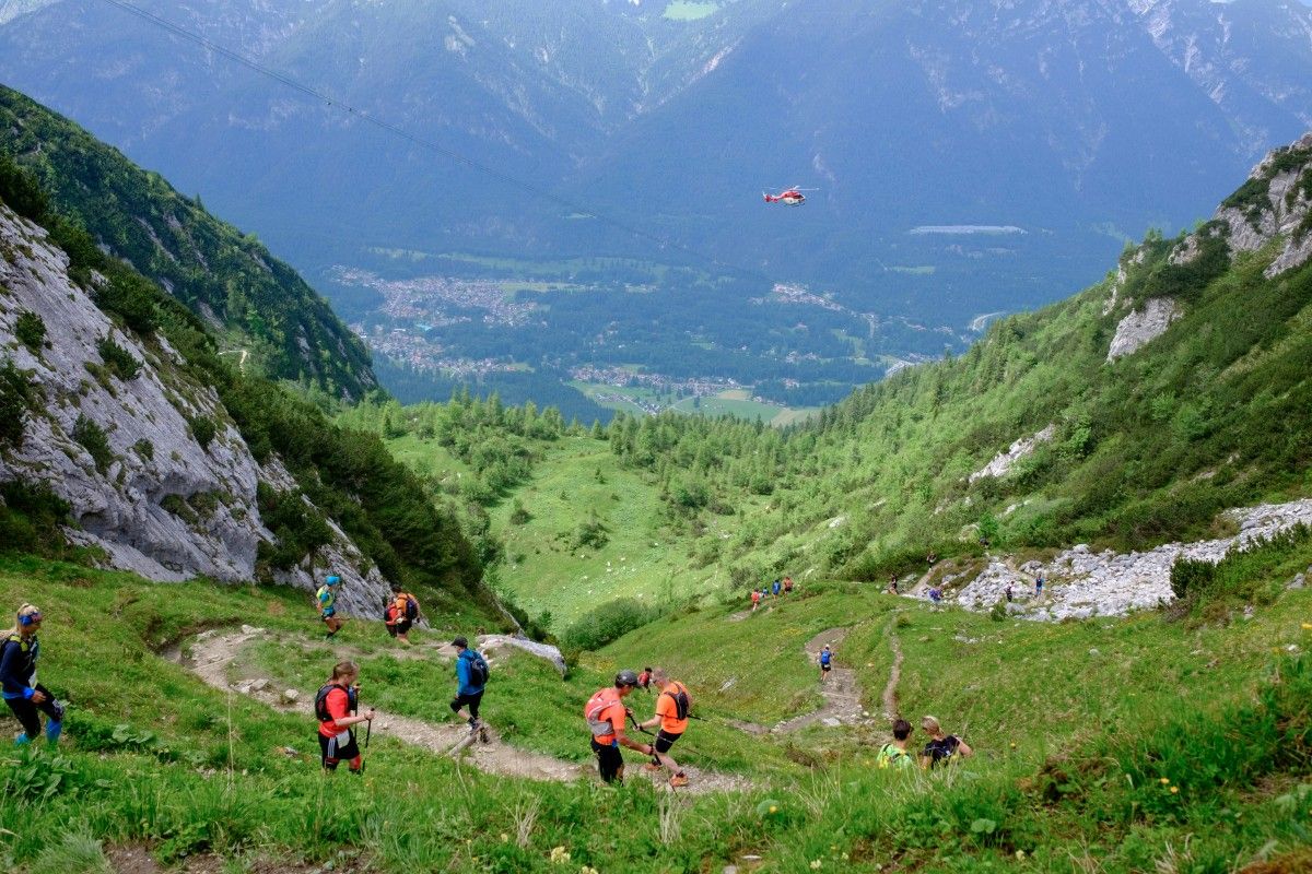 A group of people on a trail run through the hills