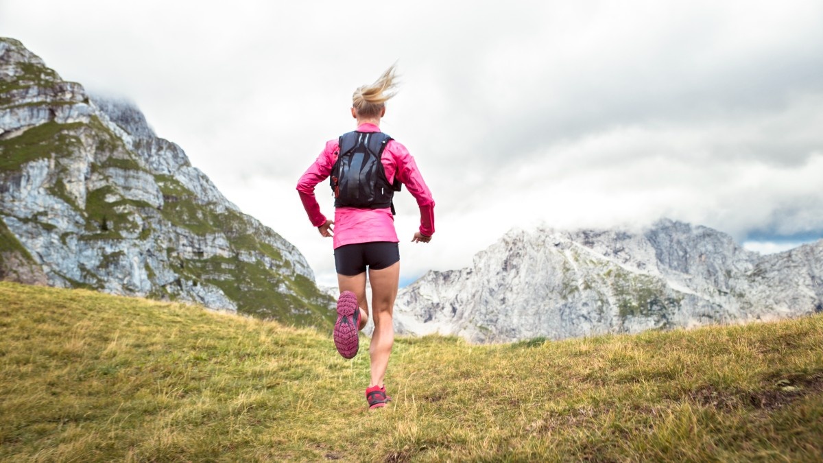 A woman trail running in shorts