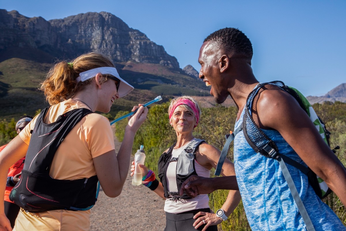 Three trail runners wearing running backpacks