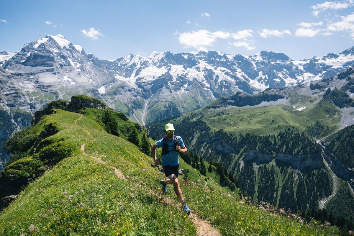 A man trail running through the mountains in shorts