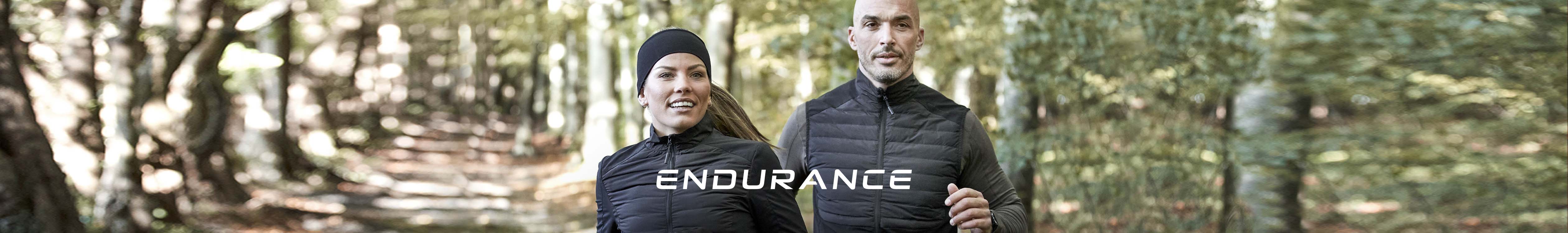 Endurance brand. A man and a woman running on a path in the woods.