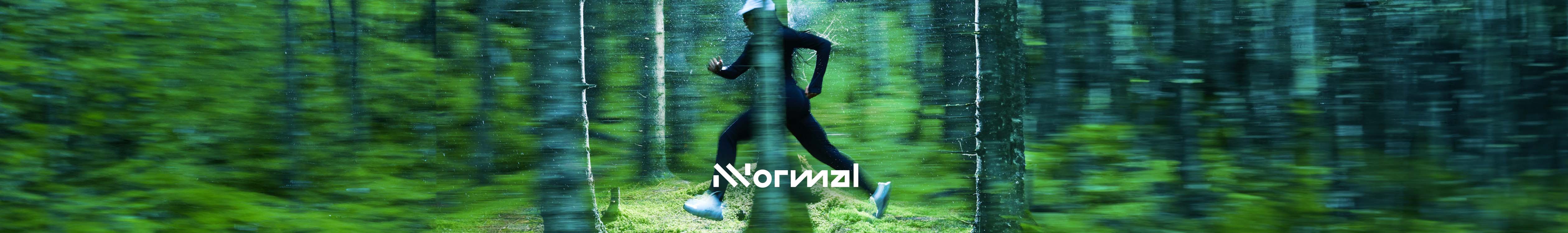 Nnormal header. A person running through the forest in their Nnormal shoes