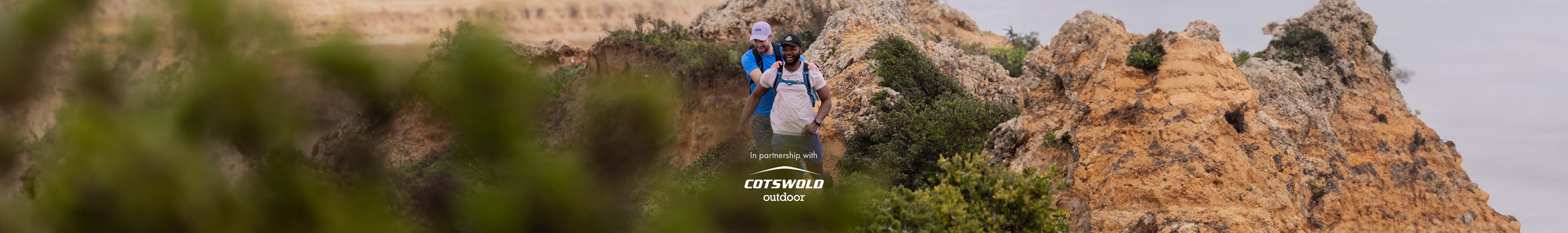 Fast hiking partnership with Cotswold Outdoor. Two people fast hiking down the mountain