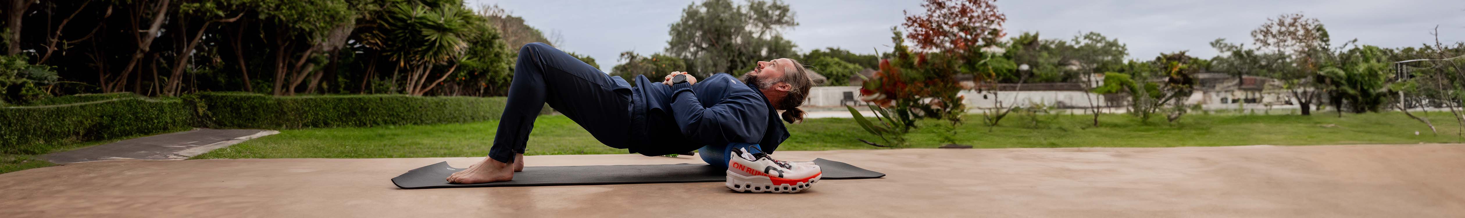 Running recovery & injury prevention. Man doing recovery excercises on a mat