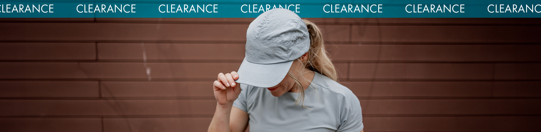 Shop accessories clearance. Woman adjusting grey cap