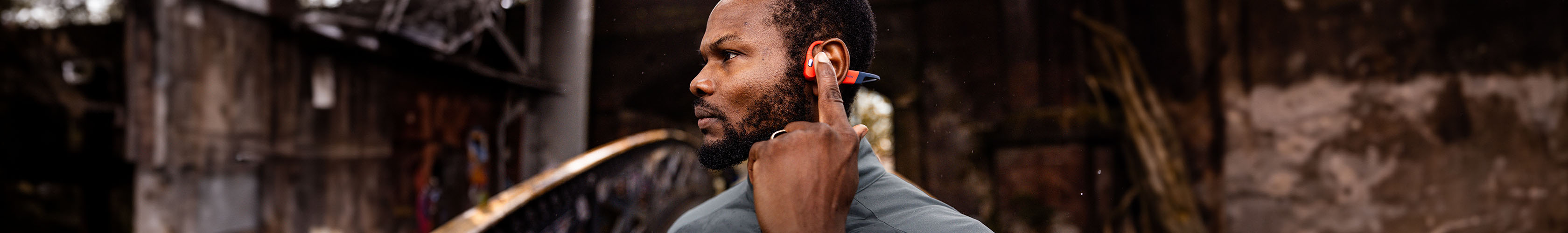 Shop electronics. A man  adjusting headphones while wearing a watch