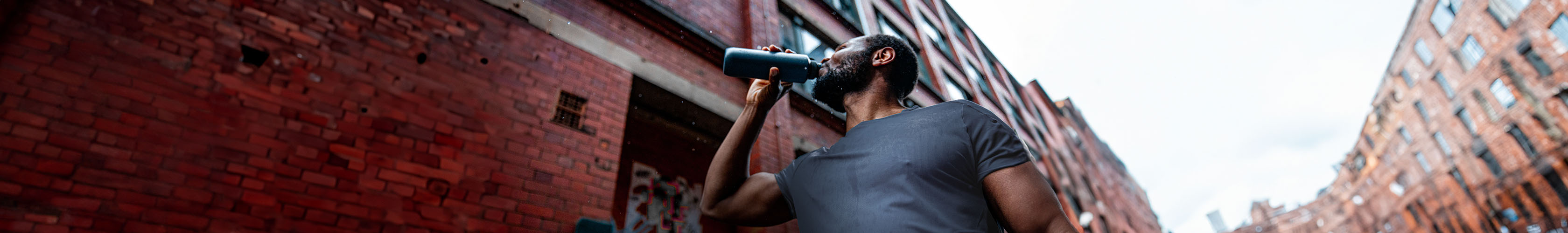 Shop Nutrition & hydration. A man in a blue T-shirt is drinking from a water bottle