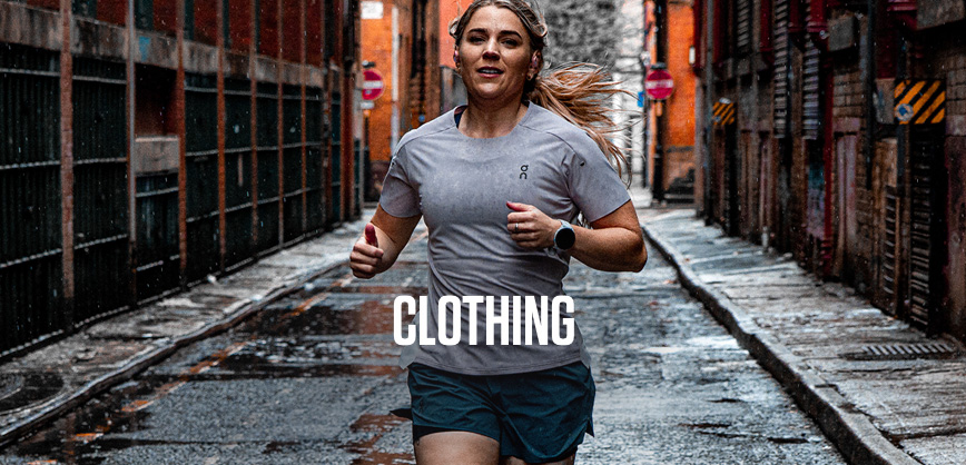 Shop new clothing. A woman running on a street in a grey T-shirt and shorts