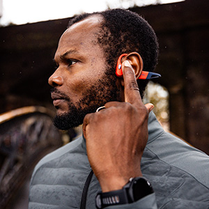 Shop electronics new season. A man adjusting his heahphones, wearing a watch on his wrist