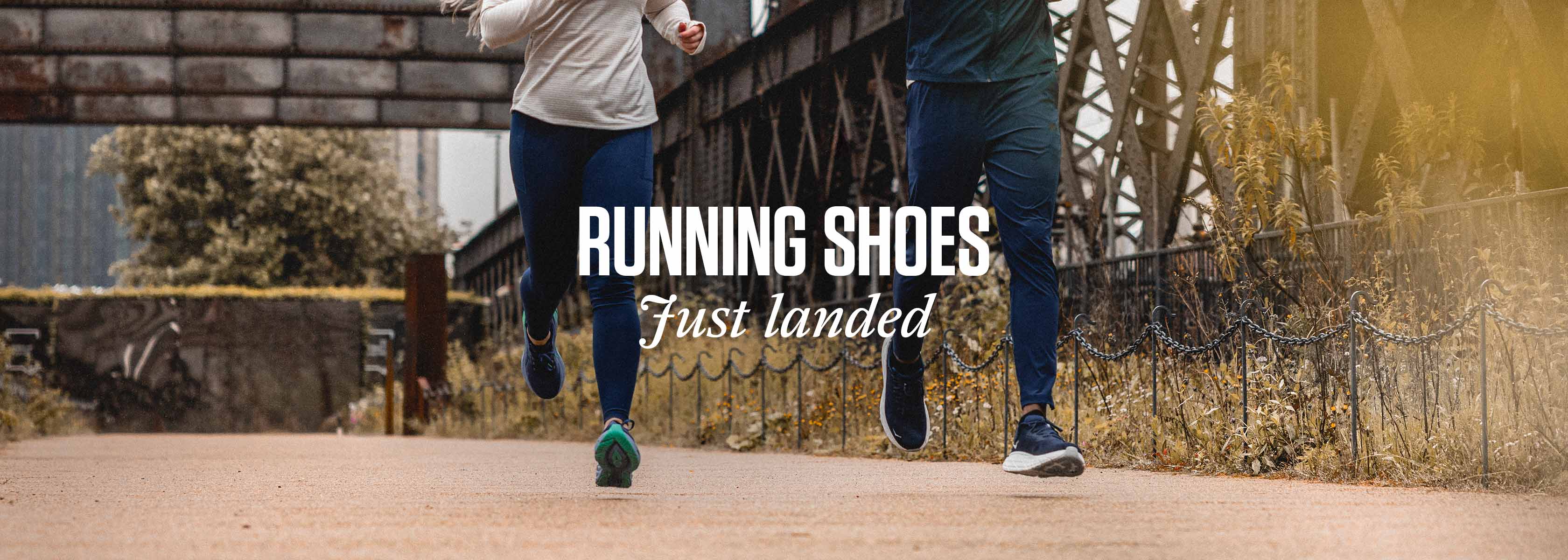 Shop latest running shoes. A man and woman running on a city street