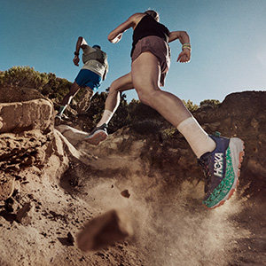 Shop Trail running shoes. Two runners on a trail