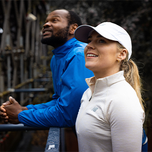 Shop Clothing new season. A man and woman standing in the street