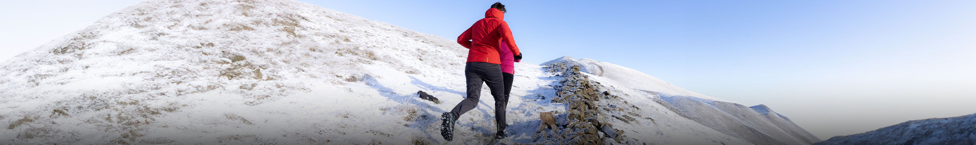 Shop cold weather running essentials. Two runners in a snowy souroundings