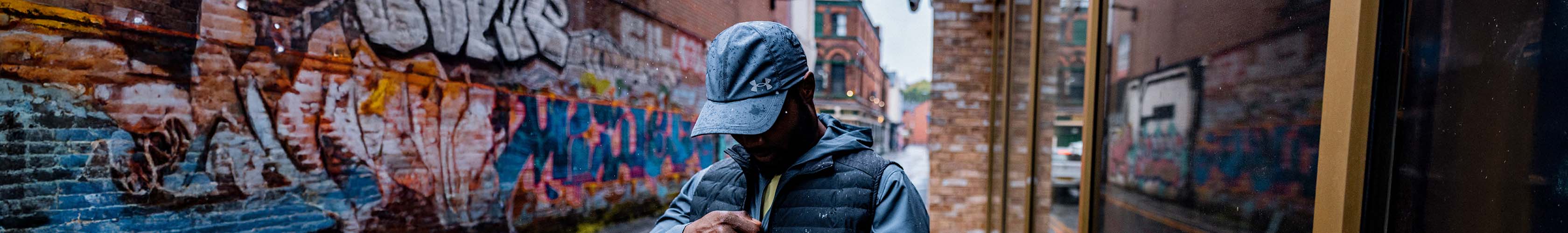 Shop running hats on Runners need. A man wearing blue running hat in an urban setting