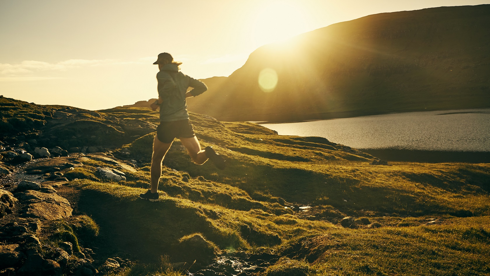 Shot of a young man out running on a trail in the mountains